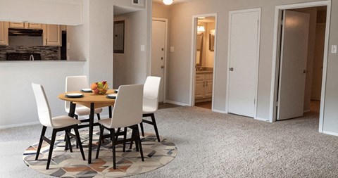 a dining room and kitchen with a table and chairs